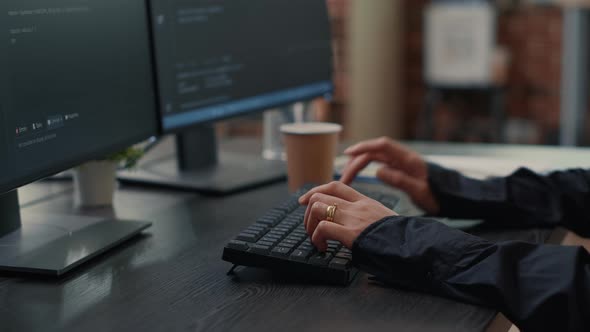 Closeup of Developer Hands Typing Code on Keyboard While Looking at Computer Screens