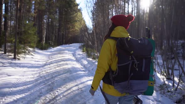 Hiker Girl in Red Hat and Yellow Hiking Jacket with Big Backpack and Thermos