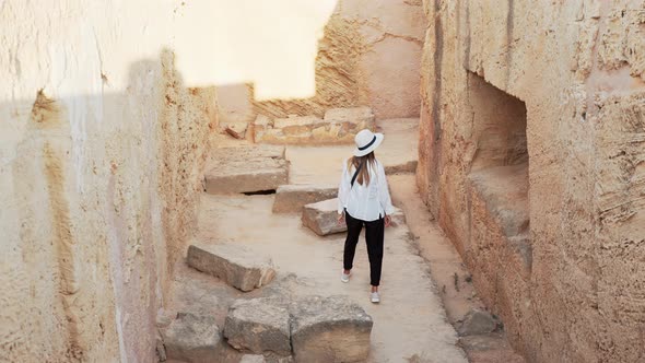 Back View of Woman Walking on Ruins of Old Building