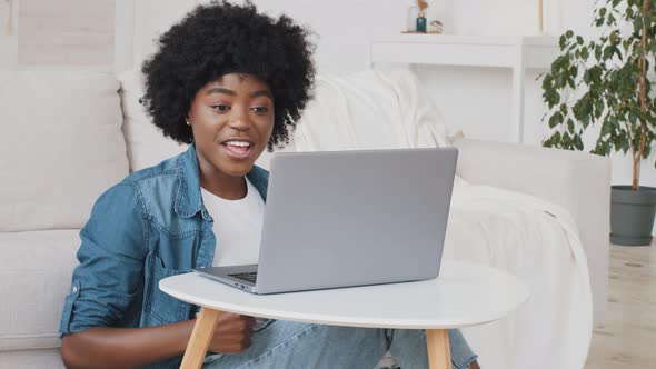 Excited Young African American Woman Winner Looks at Laptop Celebrates Online Success