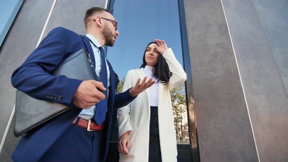 Male Boss and Female Employee Discussing Business Standing Outdoor