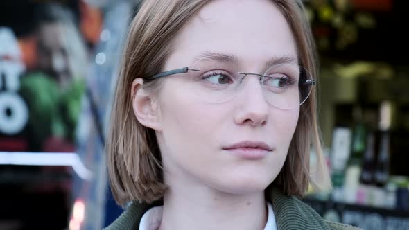 Serene Young Hipster Woman Student Wearing Glasses Looking at Camera Confidently