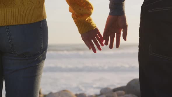 Couple holding hands by the sea