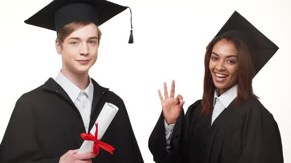 African American Young Graduate Female in Black Robe and Square Academical Cap Showing Ok While Her