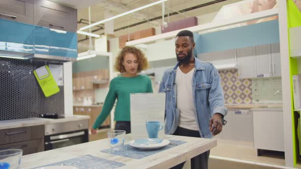 Multiethnic Couple Checking High Prices in Modern Furniture Store