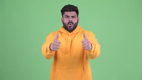 Happy Young Overweight Bearded Indian Man Giving Thumbs Up and Looking Excited