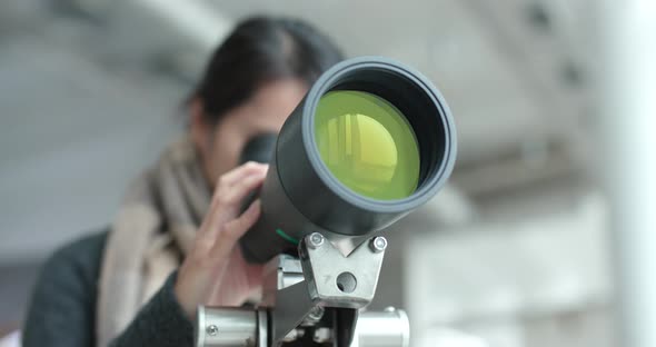 Young Woman observe through telescope