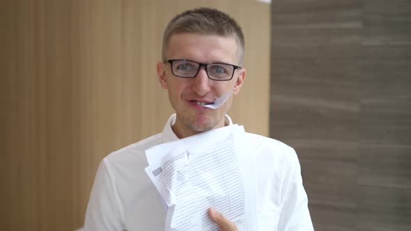 Crazy Stressed Young Businessman Eating Papers At Work
