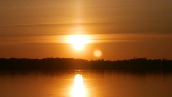 Colour Sunset Over The River With Sun And Orange Clouds