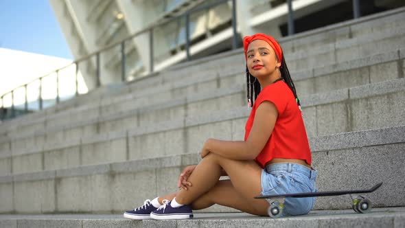 Attractive Mixed-Race Girl With Skateboard Resting Outdoor, Waiting for Friends