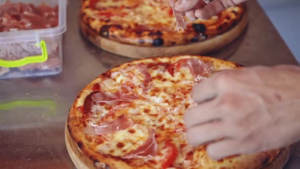 Chef making pizza. Baker hands placing ingredients on pizza