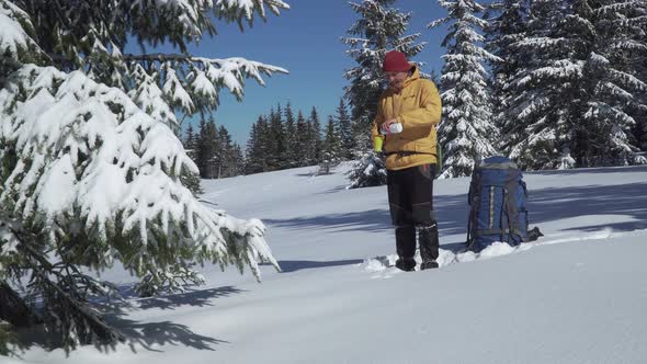 A Man Drinks Tea in Winter in a Winter Forest