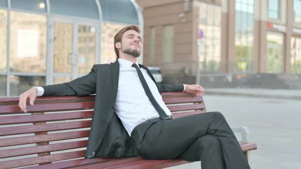 Relaxing Businessman Sitting Outdoor on Bench