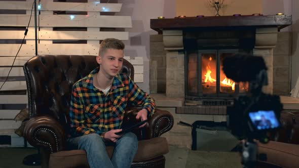 Home Video Shooting Teenage Boy Speaking Something To Camera with Tablet in His Hands