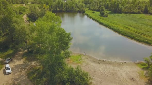 Just Married Couple on Bank of Calm Lake Near Park Aerial