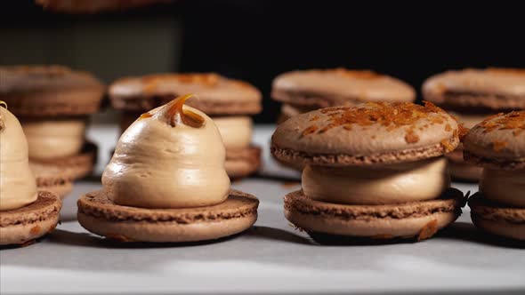 Chef is assembling caramel macarons, close-up.