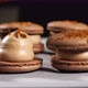 Chef is assembling caramel macarons, close-up. - VideoHive Item for Sale