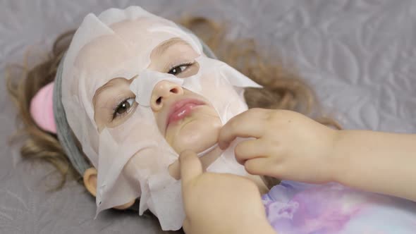 Teen Girl Applying Moisturizing Face Mask. Child Kid Take Care of Skin with Cosmetic Facial Mask