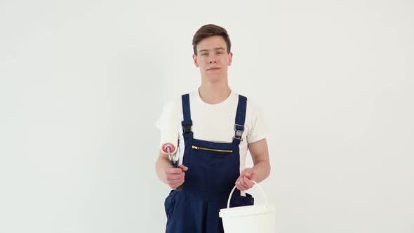 Painter with a Roller in His Hands Looks at the Camera