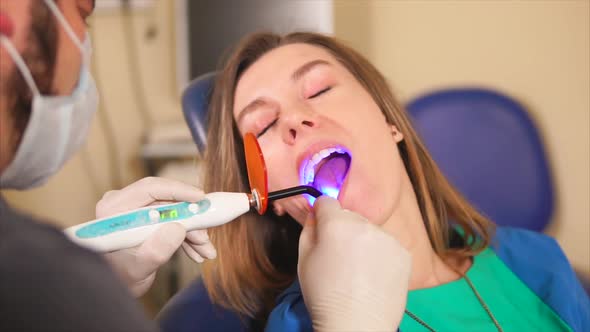 Dentist Using Ultraviolet Lamp on Patients Teeth