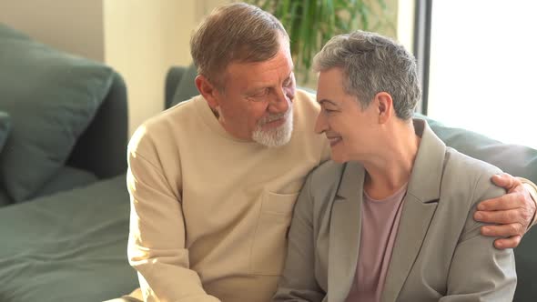 Close Portrait of Smiling Elderly Husband and Wife Looking at Camera