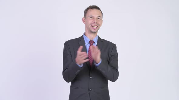 Studio Shot of Happy Businessman Clapping Hands