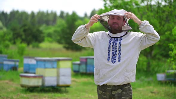 Male beekeeper in protective clothing. Portrait of beekeeper in protective mask