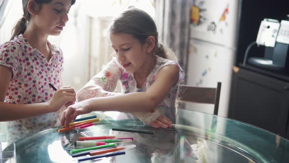 Child with a Broken Arm in a Bandage Laughs and Smiles When Her Sister Paints Her a Cast