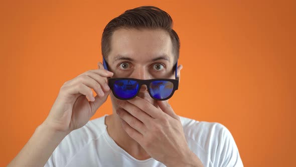 Stylish Young Man Shocked and Surprised on Orange Color Background