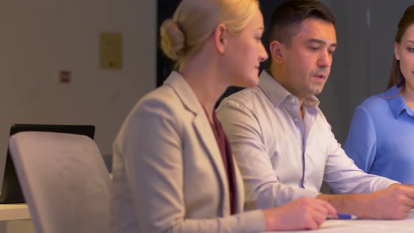 Business Team with Papers Working at Night Office 