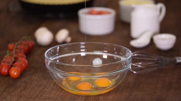 Whisking Three Fresh Raw Chicken Eggs in a Glass Bowl