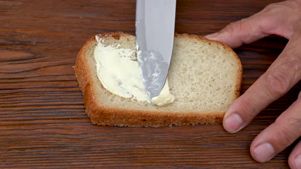 Spread Butter on Bread. Soft Butter Spreading on Slice of Sourdough Bread. Carbohydrates, Fat