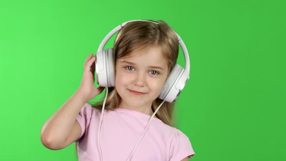 Baby Listens To Music Through the Headphones. Green Screen