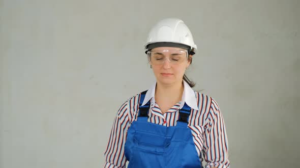 Young Woman in Protective Helmet Holding Puncher