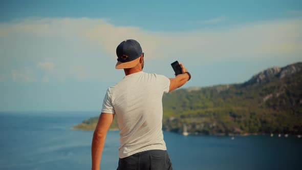 Man Using Mobile Phone For Selfie Photo. Selfie On Smartphone In Beautiful Place.