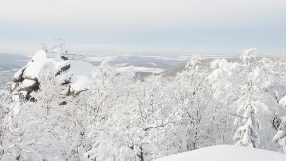 A Lookout with a Cross with a View on a Snowcovered Mountainous Winter Landscape