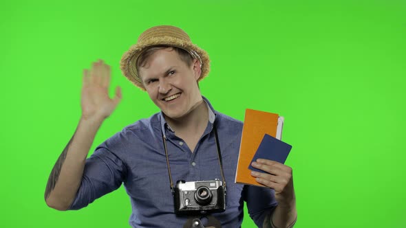 Portrait of Man Tourist Photographer with Passport and Tickets Waving His Hand