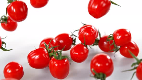 Super Slow Motion Shot of Cherry Tomatoes Falling on White Background at 1000Fps