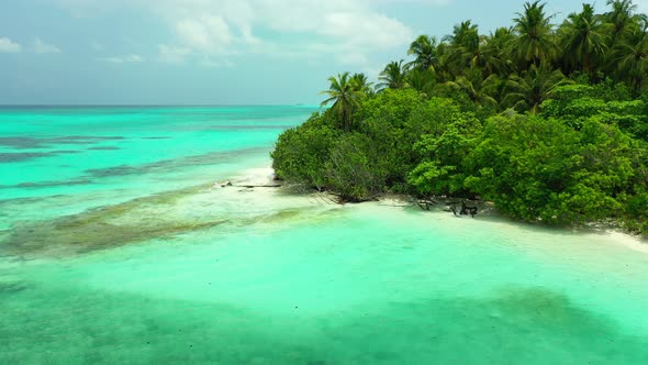 Wide fly over tourism shot of a white sandy paradise beach and blue water background in colorful 4K