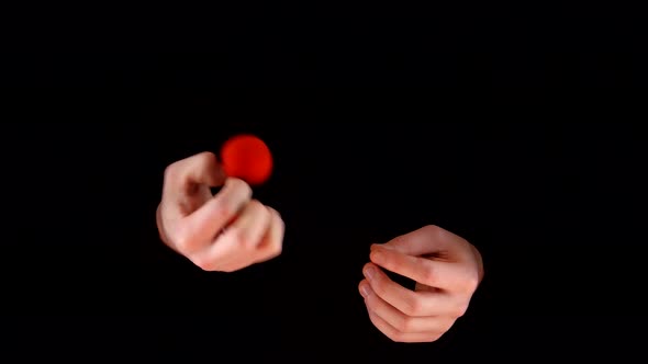 Magician Making Trick with Red Balls on Black Background