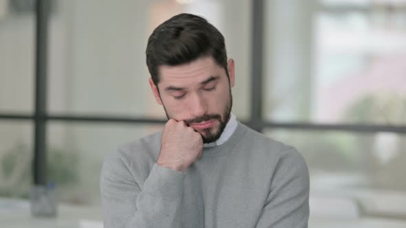 Portrait of Sleepy Young Man Taking Nap in Office