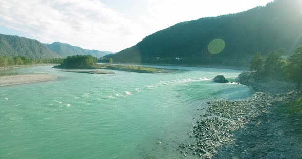 Low Altitude Flight Over Fresh Fast Mountain River with Rocks at Sunny Summer Morning.