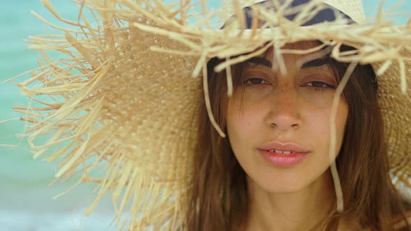 Closeup Face Smiling Woman Wearing Straw Hat at Beach in Sunshine Sunrise on Seashore