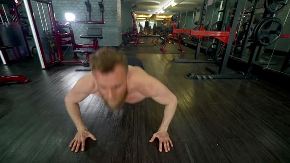 Shirtless Muscular Athlete Doing the Clap Pushup in an Indoor Gym