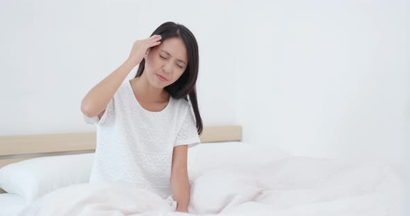 Woman feeling back pain and tired on bed 