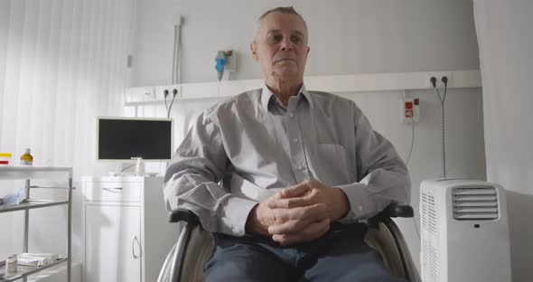 Senior Male Patient Sitting Alone in Wheelchair Feeling Depressed