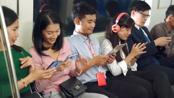 Young People Using Mobile Phone in Public Underground Train
