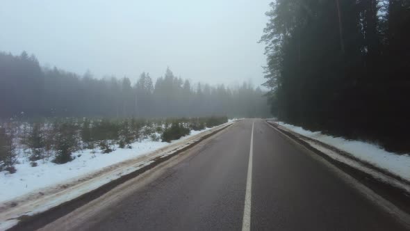 Car driving on winter country road in fog
