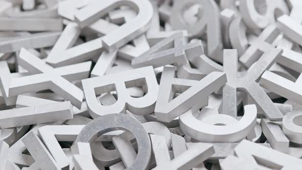 Full Frame Closeup Looped Slowly Rotating Background of Silver Metal Letters with Selective Focus