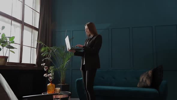 Confident Businesswoman Working on a Laptop in Her Modern Blue Modern Office Interior. Stylish